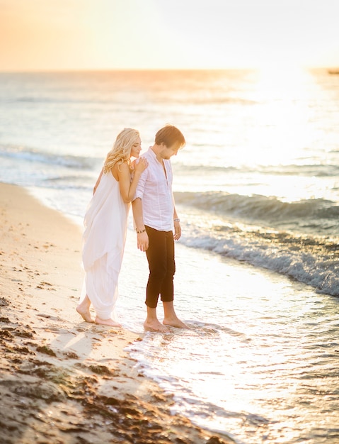 Photo gratuite beau couple élégant posant sur la plage