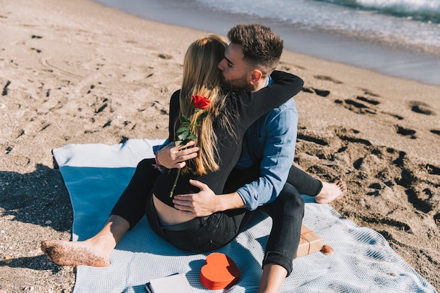 Photo gratuite beau couple étreindre heureusement sur le rivage