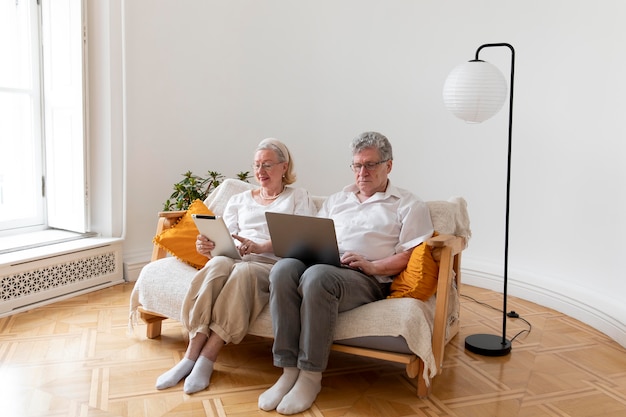 Photo gratuite beau couple de grands-parents apprenant à utiliser un appareil numérique