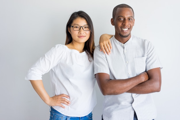 Beau couple interracial positif en regardant la caméra.