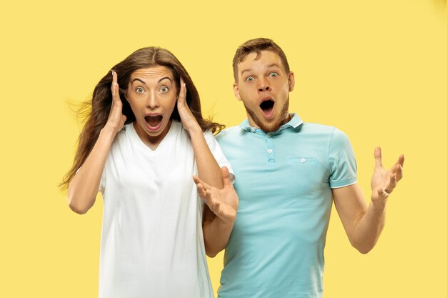 Beau couple isolé sur fond de studio jaune