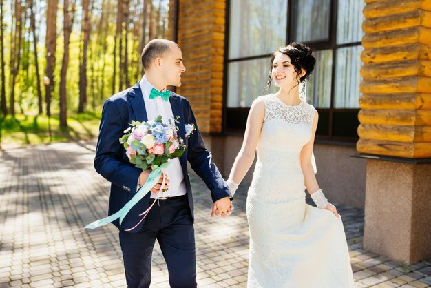 Beau couple de jeunes mariés, la mariée et le marié marchant