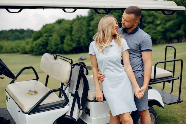 Beau couple jouant au golf sur un parcours de golf