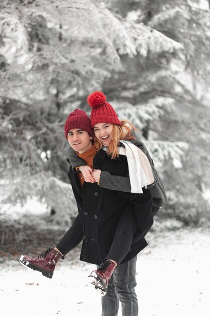 Beau couple jouant à l'extérieur en hiver