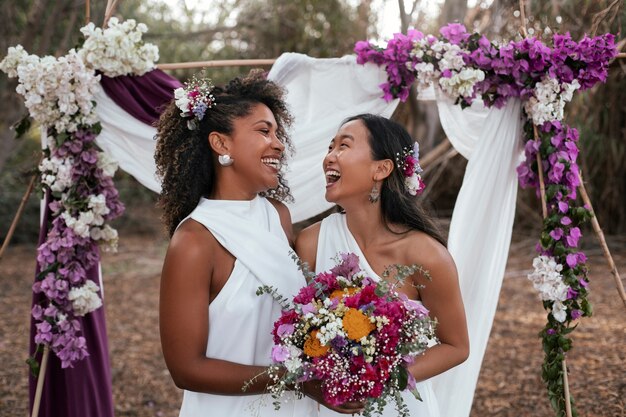 Photo gratuite un beau couple de lesbiennes fête leur jour de mariage à l'extérieur.