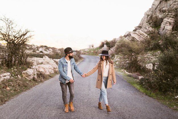 Beau couple marchant sur une route