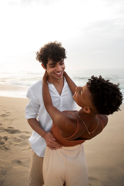 Photo gratuite beau couple montrant de l'affection sur la plage près de l'océan