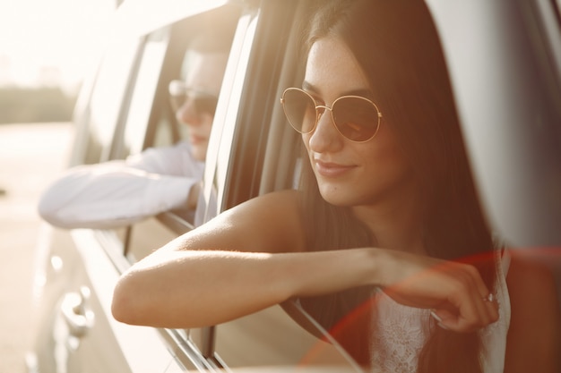 Beau couple passe du temps dans un parc d'été assis dans une voiture