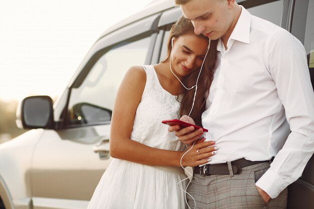 Beau couple passe du temps dans un parc d'été près d'une voiture