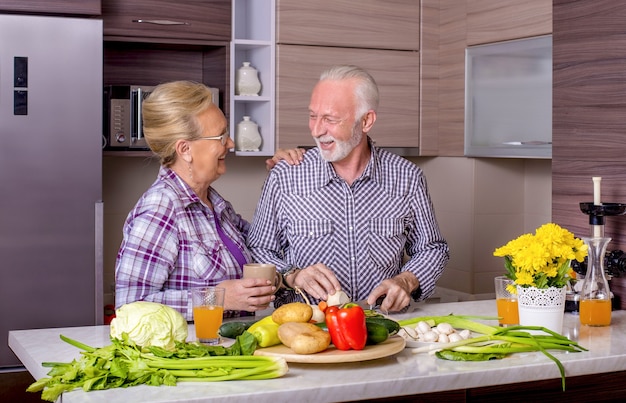 Beau couple de personnes âgées cuisiner dans la cuisine les uns avec les autres