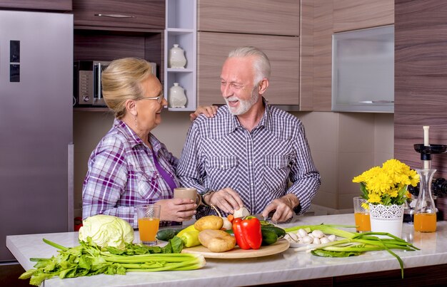 Beau couple de personnes âgées cuisiner dans la cuisine les uns avec les autres