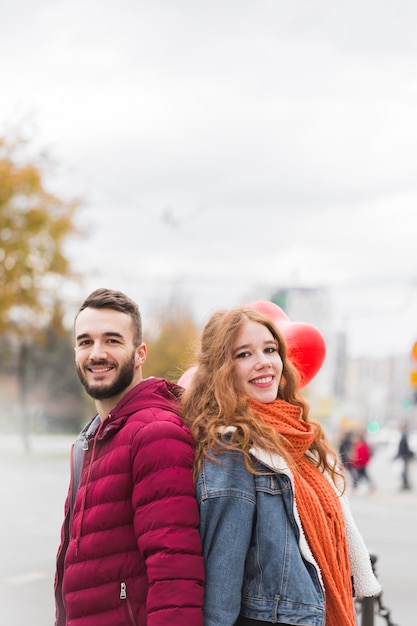 Photo gratuite beau couple posant dos à dos