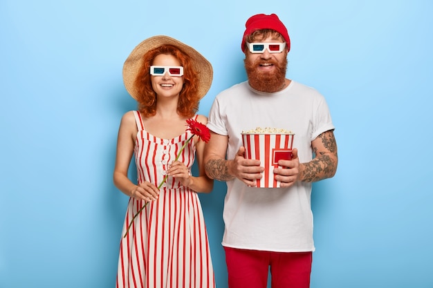 Beau couple regarde joyeusement l'écran, regarde un film drôle, rit d'émotions positives