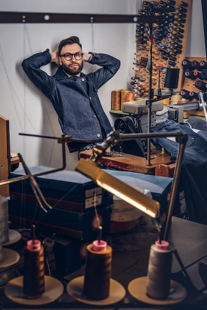 Beau créateur de mode barbu prenant une pause dans son travail et réfléchissant à de nouveaux designs.