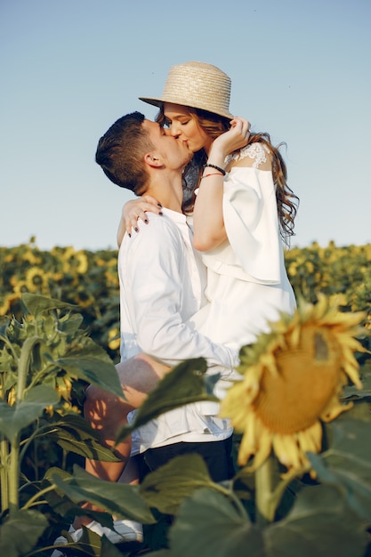 Beau et élégant couple dans un champ de tournesols