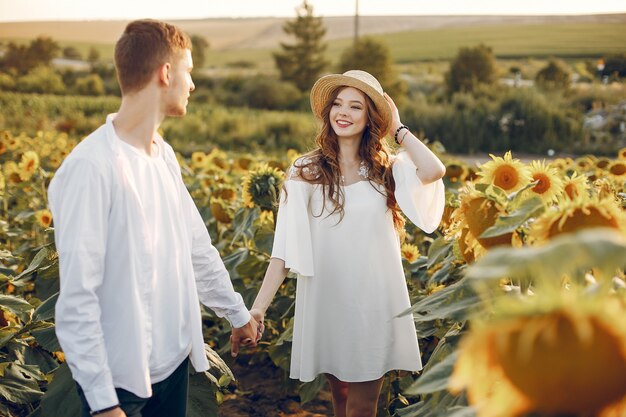 Beau et élégant couple dans un champ de tournesols