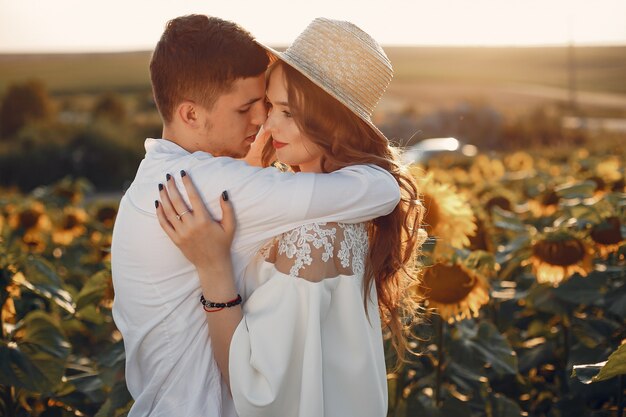 Beau et élégant couple dans un champ de tournesols