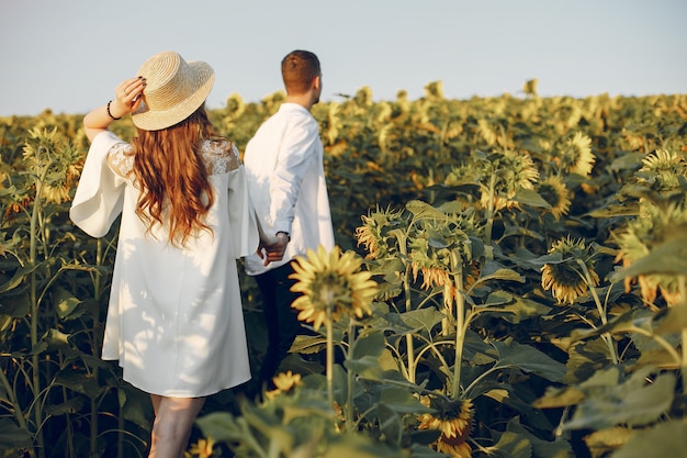 Beau et élégant couple dans un champ de tournesols