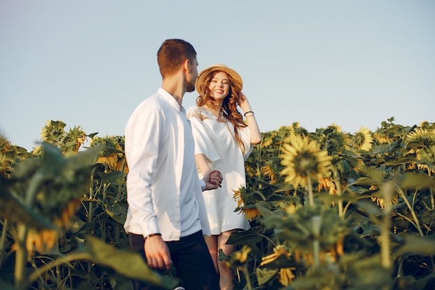 Beau et élégant couple dans un champ de tournesols