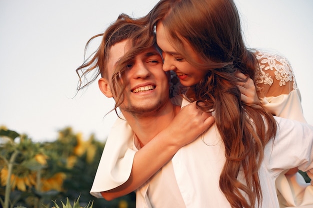 Beau et élégant couple dans un champ de tournesols