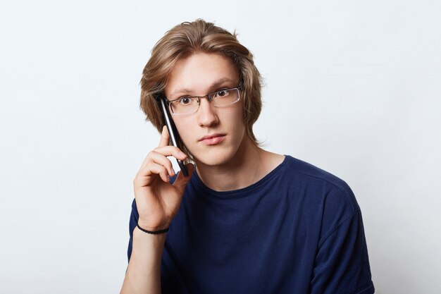 Beau entrepreneur masculin, portant des lunettes élégantes, faisant appel à son partenaire