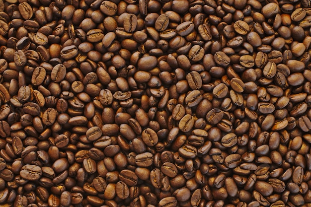 Beau gros plan de grains de café noirs frais bruns