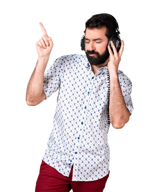 Beau homme brune à la barbe écoutant de la musique