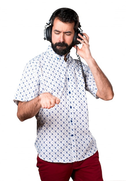 Beau homme brune à la barbe écoutant de la musique