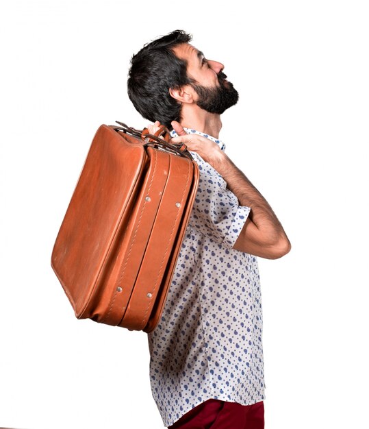 Beau homme brune à la barbe tenant une mallette vintage