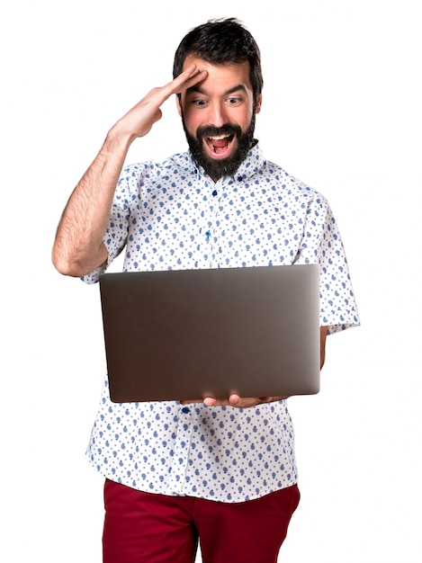 Beau homme marron avec barbe avec ordinateur portable