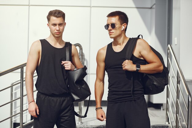 Beau hommes dans un vêtement de sport debout dans une ville