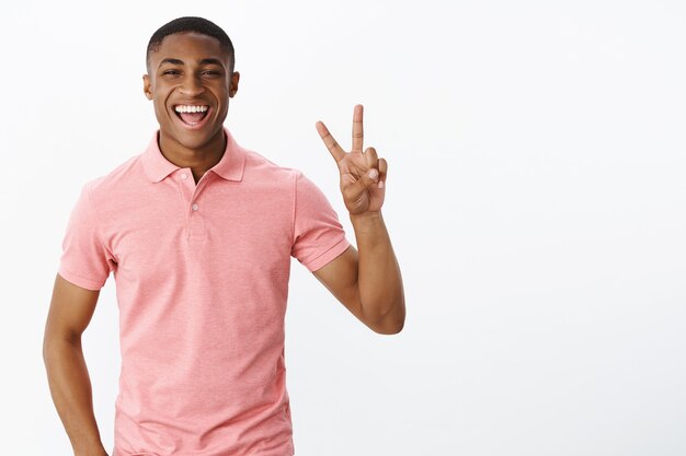 Beau jeune afro-américain avec tshirt polo rose