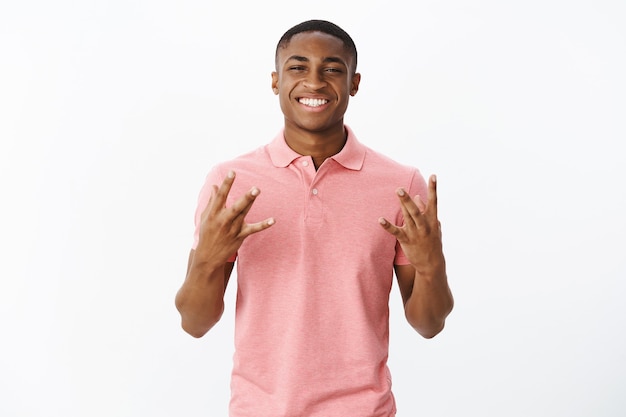 Beau jeune afro-américain avec tshirt polo rose