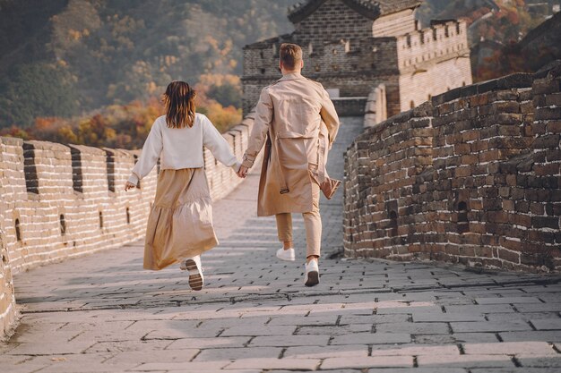 Beau jeune couple courir et sauter à la Grande Muraille de Chine.