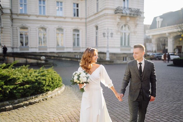 Beau jeune couple élégant de la mode marchant dans la rue en ville