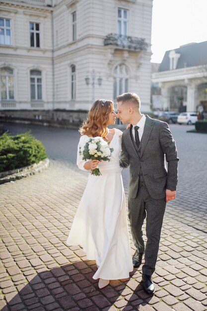 Beau jeune couple élégant de la mode marchant dans la rue en ville