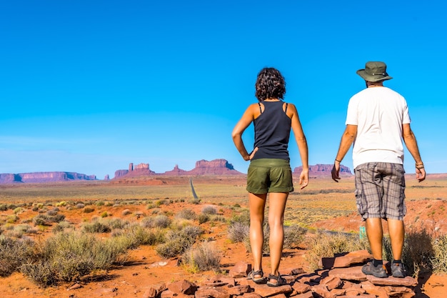 Photo gratuite beau jeune couple européen profitant de la belle vue sur la célèbre monument valley dans l'utah, aux états-unis