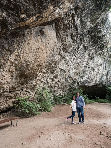Beau jeune couple explorant une grotte dans les montagnes. Profiter de la nature.