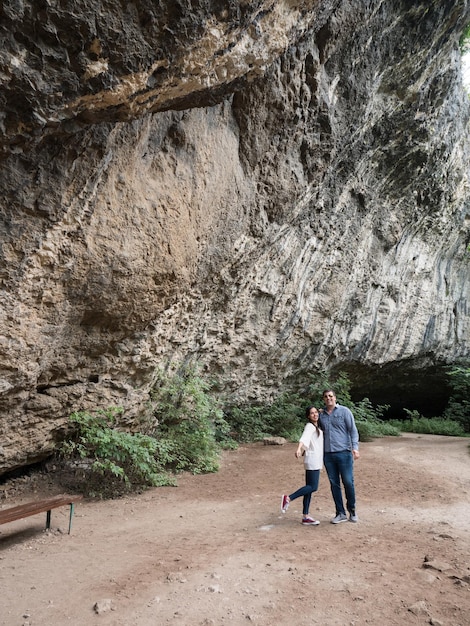 Beau jeune couple explorant une grotte dans les montagnes. Profiter de la nature.