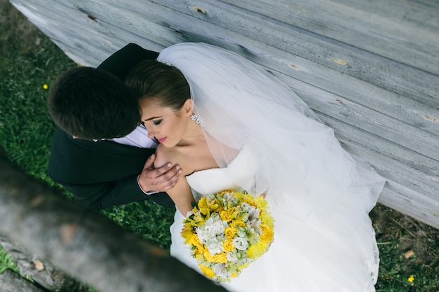 Beau jeune couple de mariage se tient près de la vieille maison en bois