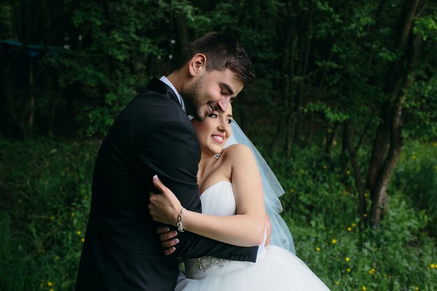 Beau jeune couple posant dans la forêt sous un angle proche