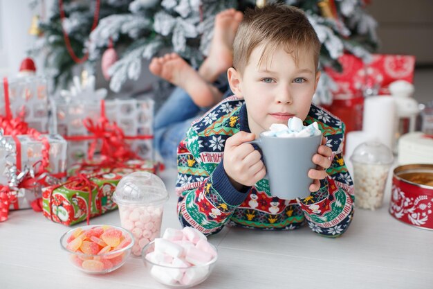 beau jeune garçon avec tasse à la maison