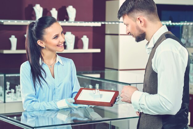 Beau jeune homme achetant des bijoux à la bijouterie locale