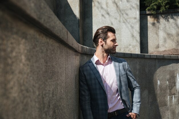 Beau jeune homme d'affaires marchant à l'extérieur