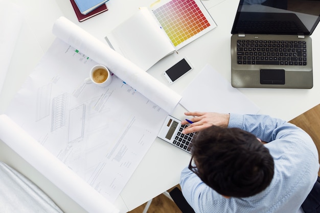 Photo gratuite beau jeune homme d'affaires travaillant dans le bureau.