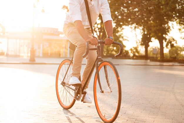 Beau jeune homme africain tôt le matin à vélo