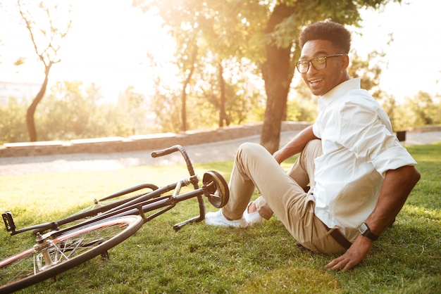 Beau jeune homme africain tôt le matin à vélo