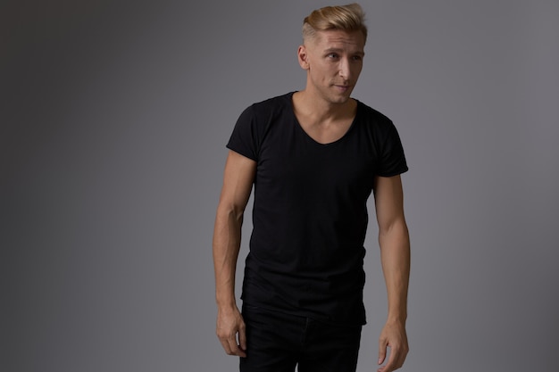 Beau jeune homme blond posant au studio