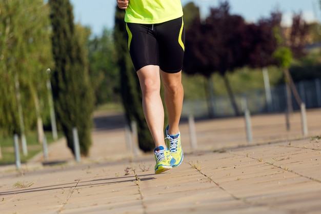 Beau jeune homme courir dans le parc.