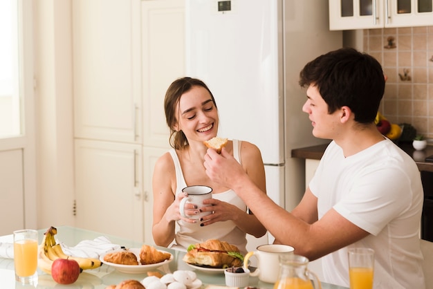 Beau jeune homme et femme prenant son petit déjeuner